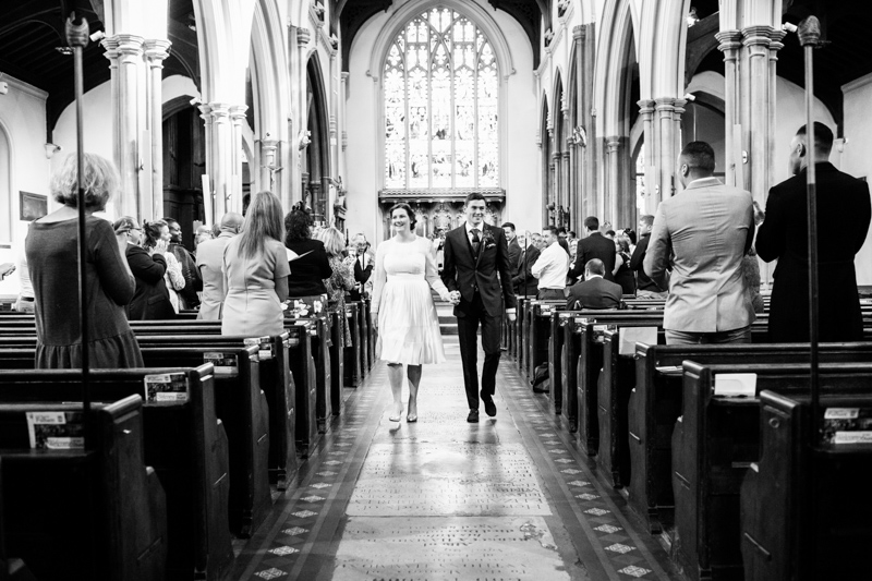 A bride and groom walking down the church aisle