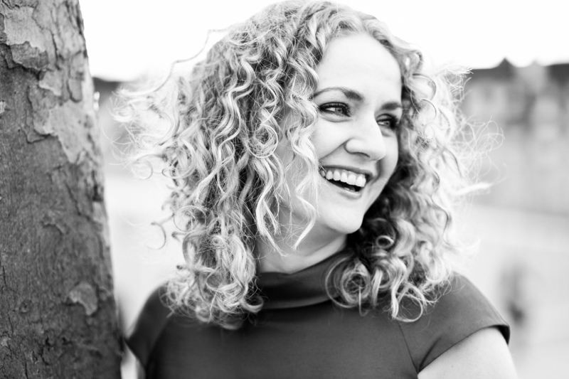 Lady with curly hair smiling. 