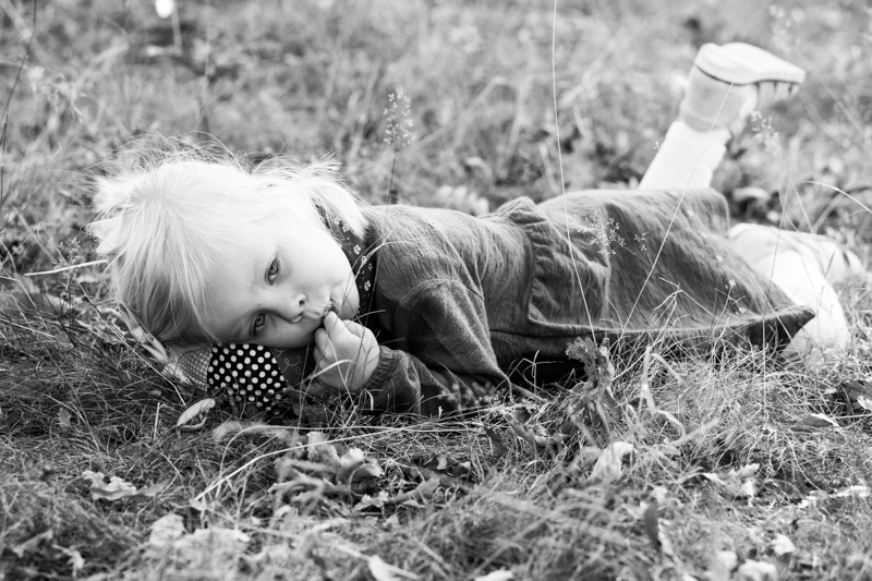 Girl lying on the grass on a cuddly toy. 