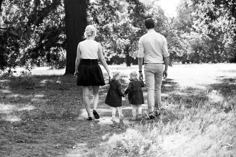 Family of four walking away in park. 