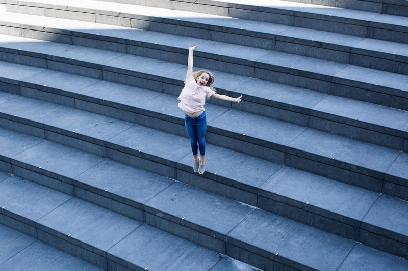 Young lady jumping down steps. 