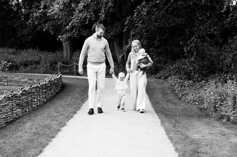 Mum and dad with little girl walking and carrying baby. 