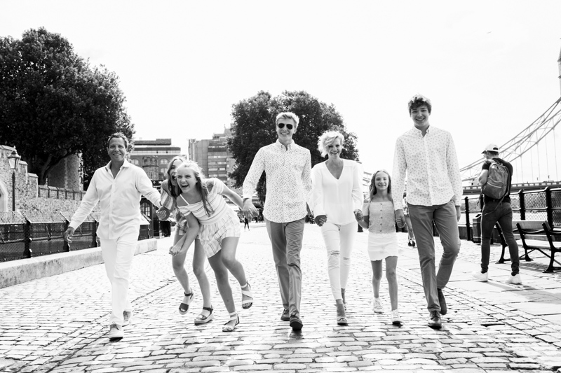 Family of seven walking in London laughing. 