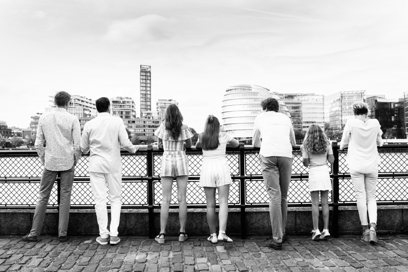 Back view of family of seven looking at City of London. 