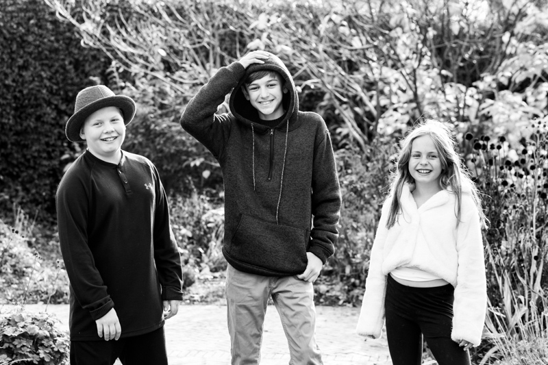 Three smiling children in a park.