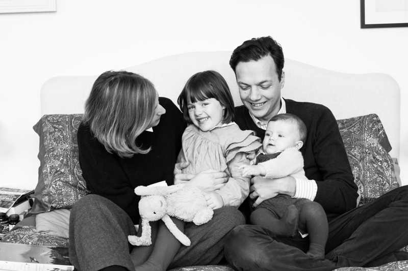 Mum, dad, little girl and baby cuddling and laughing.
