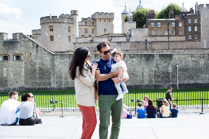 Family of three standing in front of the Tower of London. 