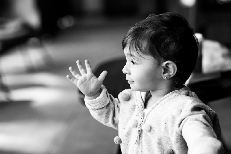 Little girl waving with her hand. 