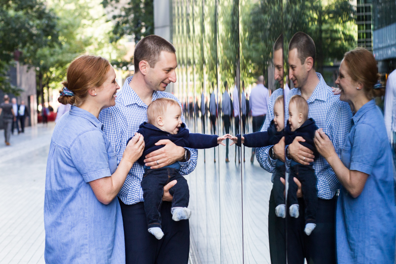 Mum, dad and baby looking at their reflections.