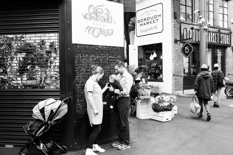 Parents with the baby and pram standing in Borough Market. 