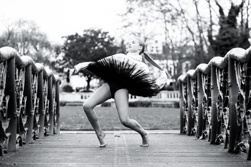 Ballet dancer in black tutu on bridge