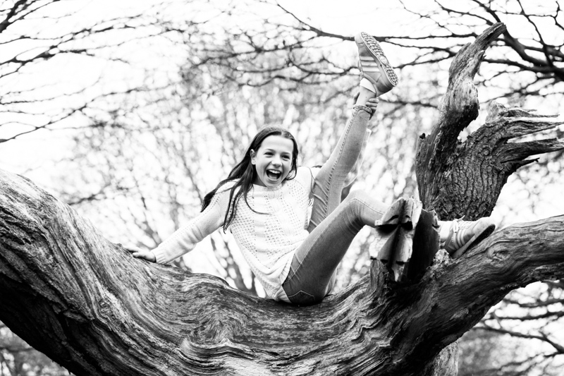 Girl with her leg in the air up a tree