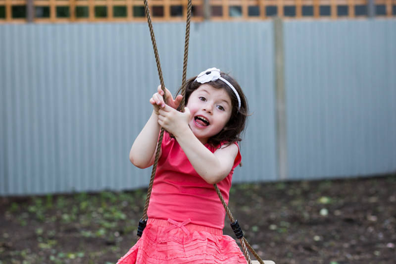 Girl looking happy whilst on a swing. 