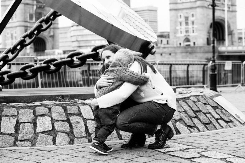 son hugging mum with Tower Bridge in the background. 