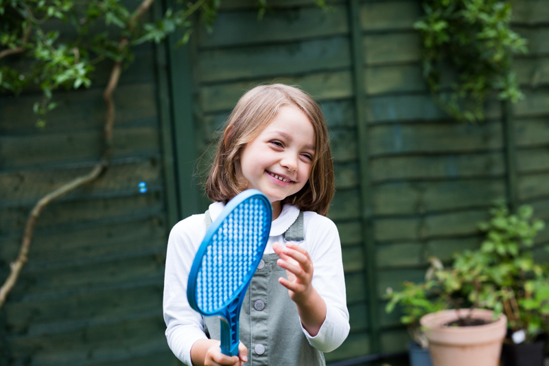Girl smiling with tennis racket