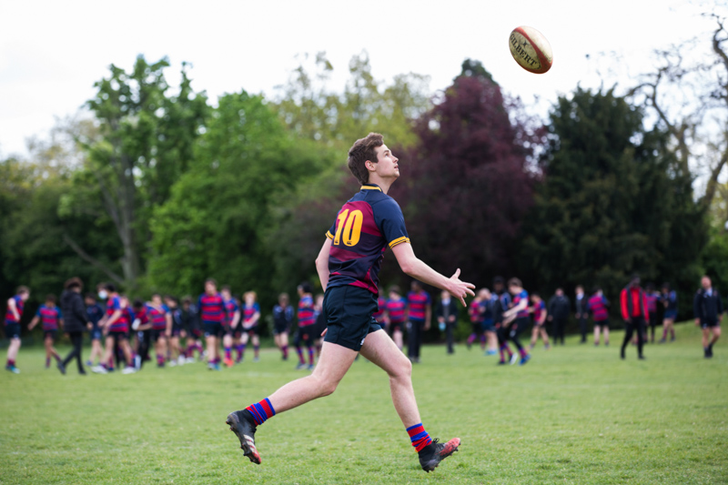 boy chasing a rugby ball. 