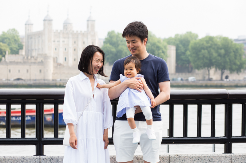 Man, lady and baby in front of the Tower of London. 