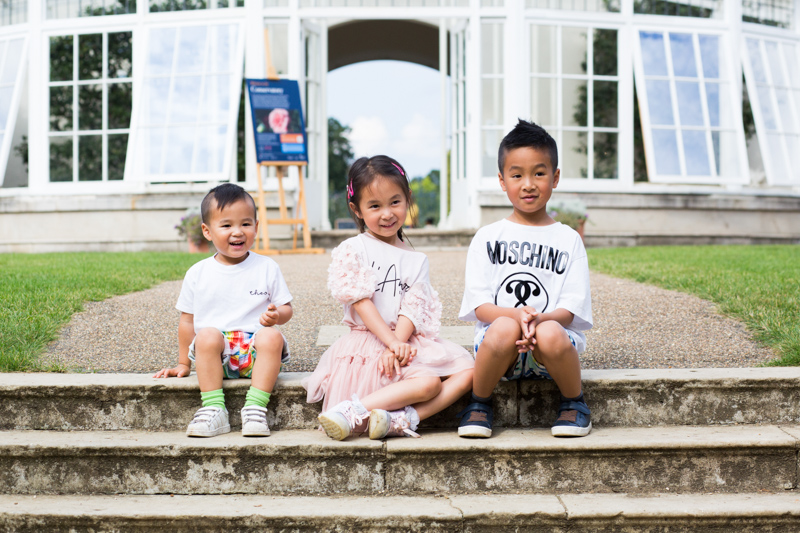 Three children sitting on stone steps. 