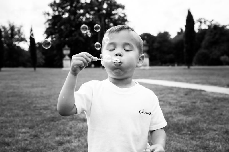 little boy blowing bubbles in the park. 