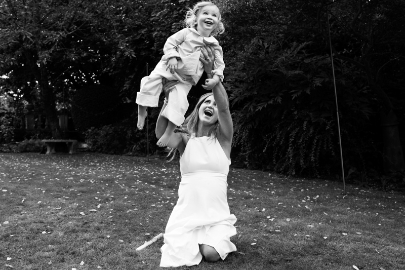 Lady holding little girl high in the air. 