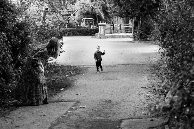 Little boy running towards a lady in the park. 