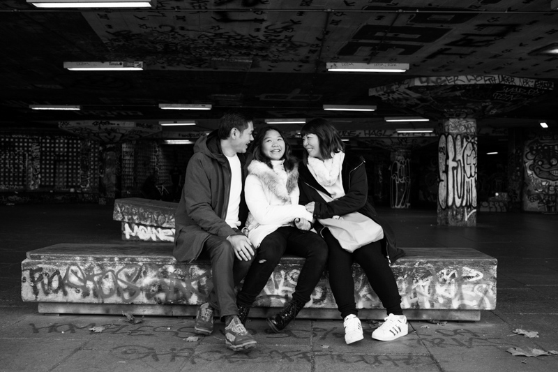 Three people laughing, surrounded by graffiti. 