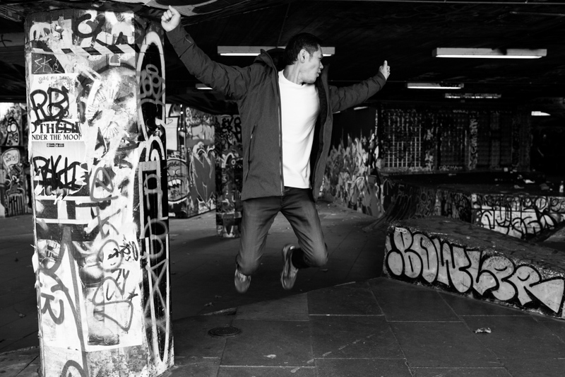 Man jumping in the air surrounded by graffiti. 