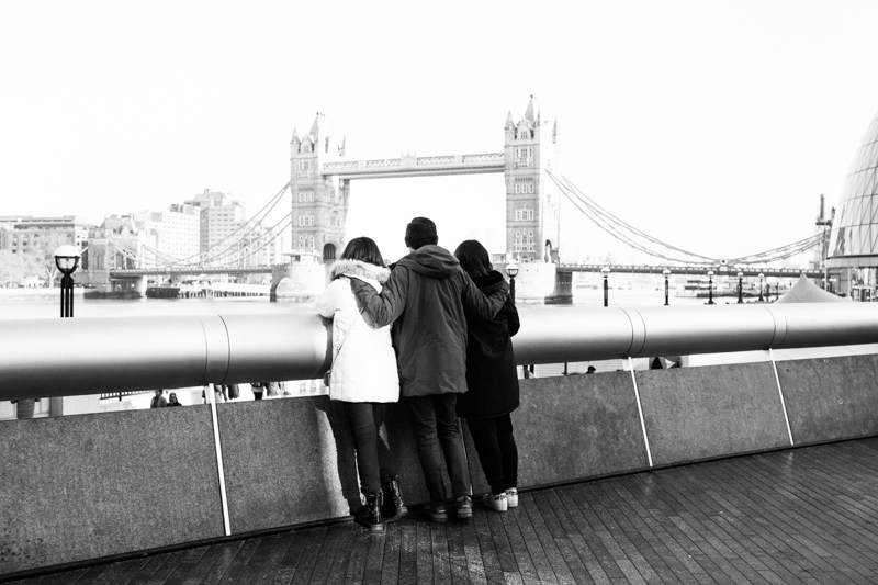Three people looking at Tower Bridge