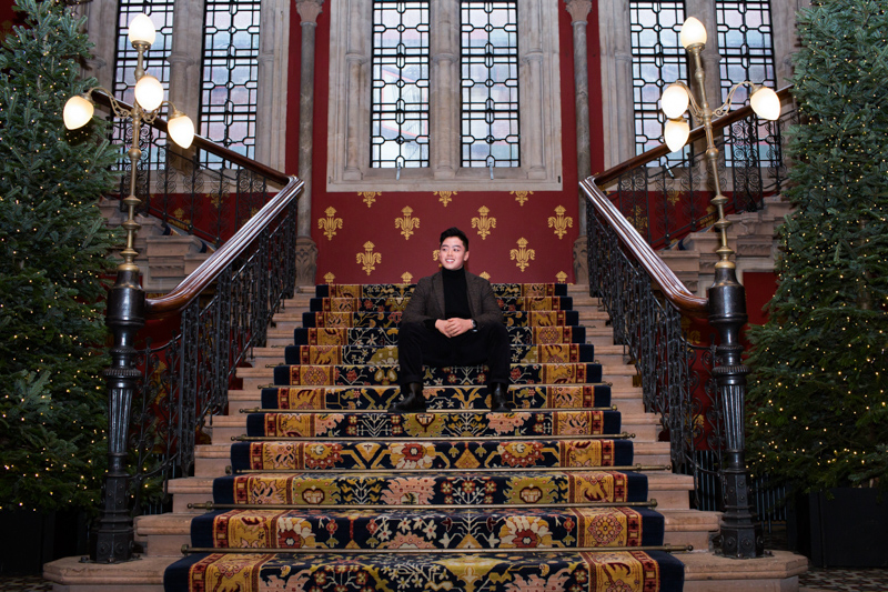 Man sitting on staircase in St Pancras Hotel. 