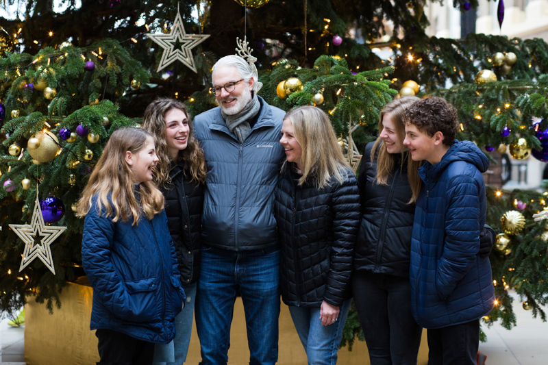 Man, lady and four children in front of Christmas tree.