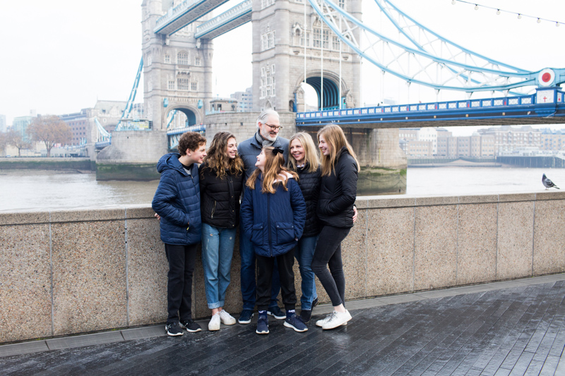 Two men and four ladies with Tower Bridge behind them.