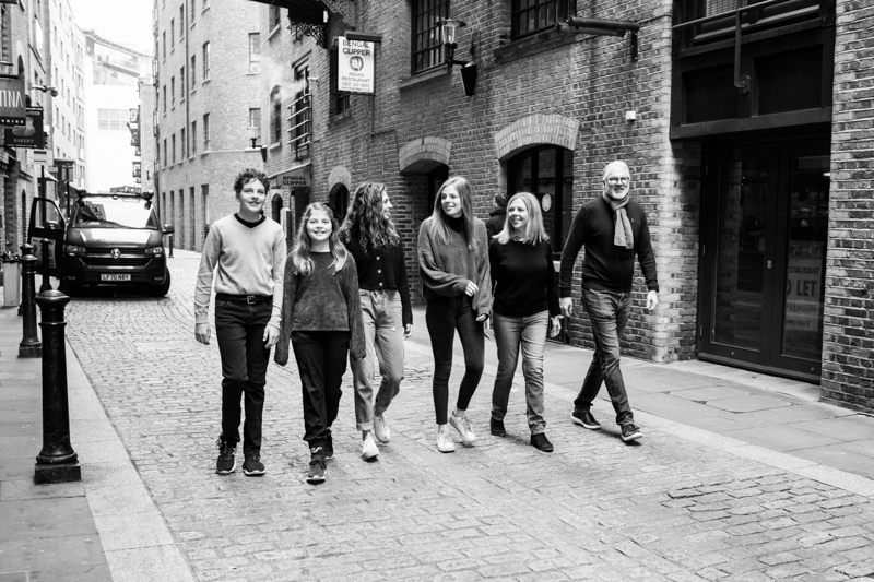Six people walking down a cobbled street.