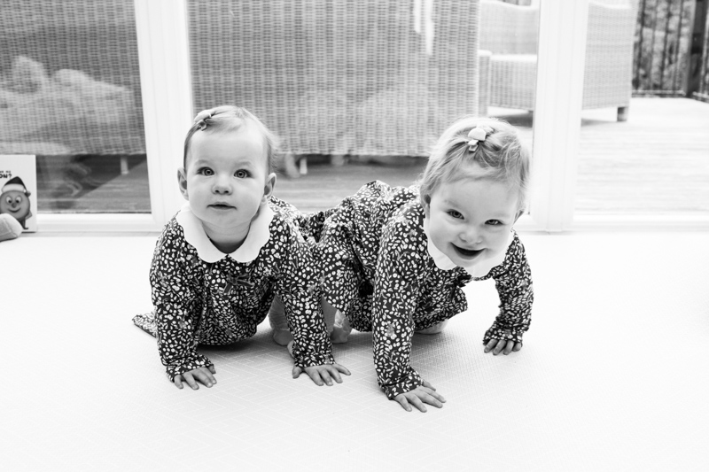 Two baby girls crawling on the floor. 