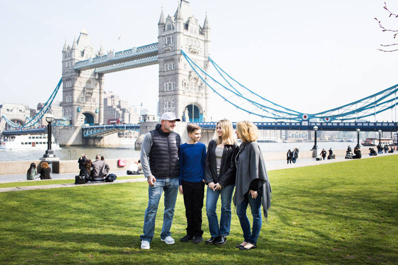 Four people looking at each other with Tower Bridge in the background. 