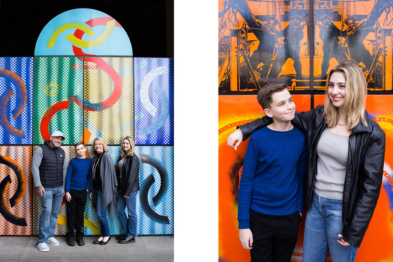 Four people standing in front of a colourful wall. 