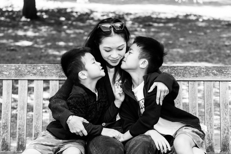 two young boys kissing their mum