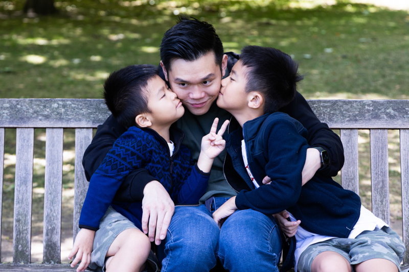 two young boys kissing a man