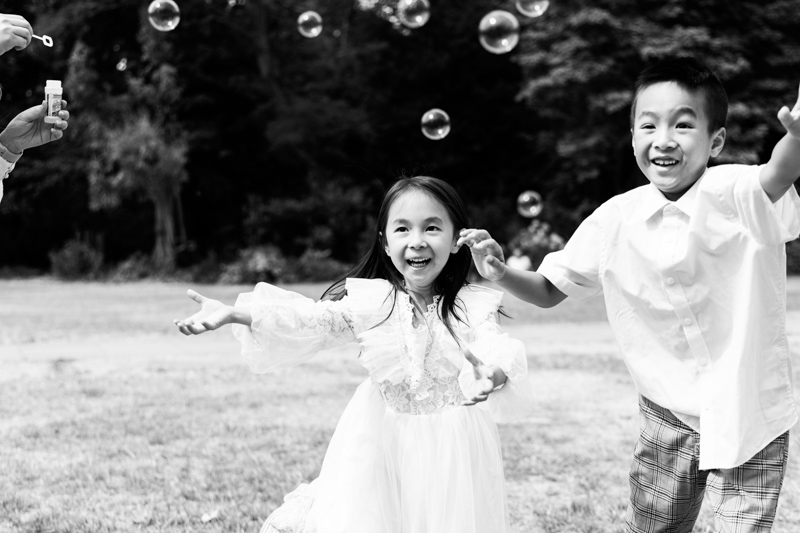 girl and boy chasing bubbles