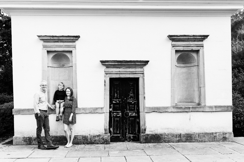 Mum, dad and boy in front of old building. 