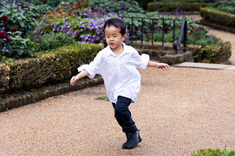 Boy in white shirt running in a park. 