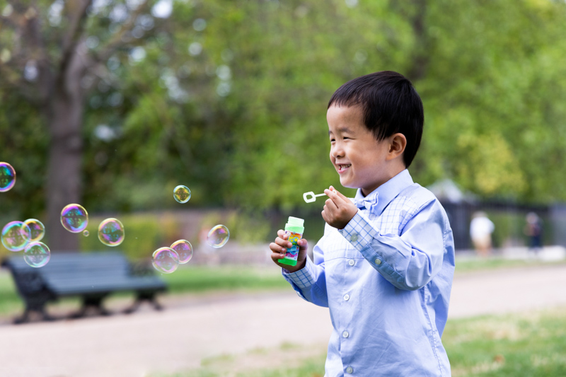 Smiling boy blowing bubbles. 