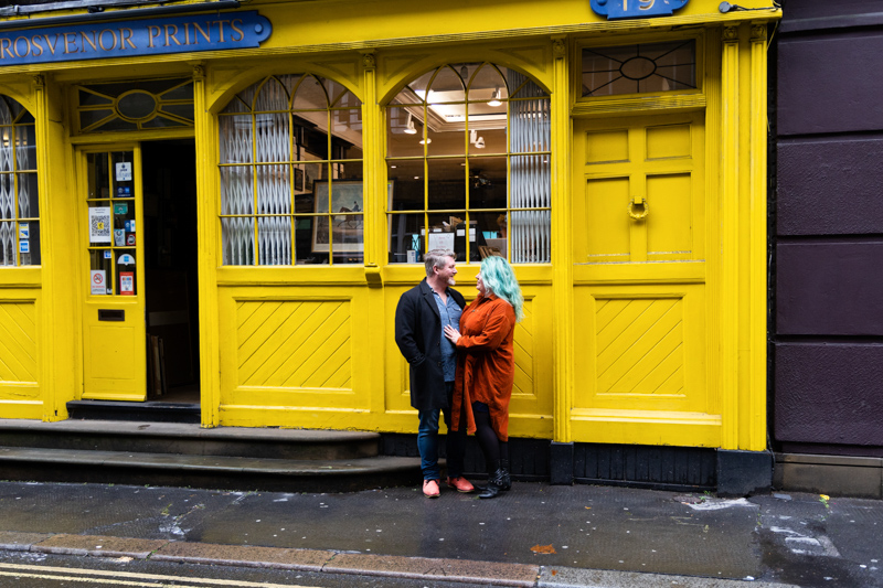 Couple in front of a yellow shop
