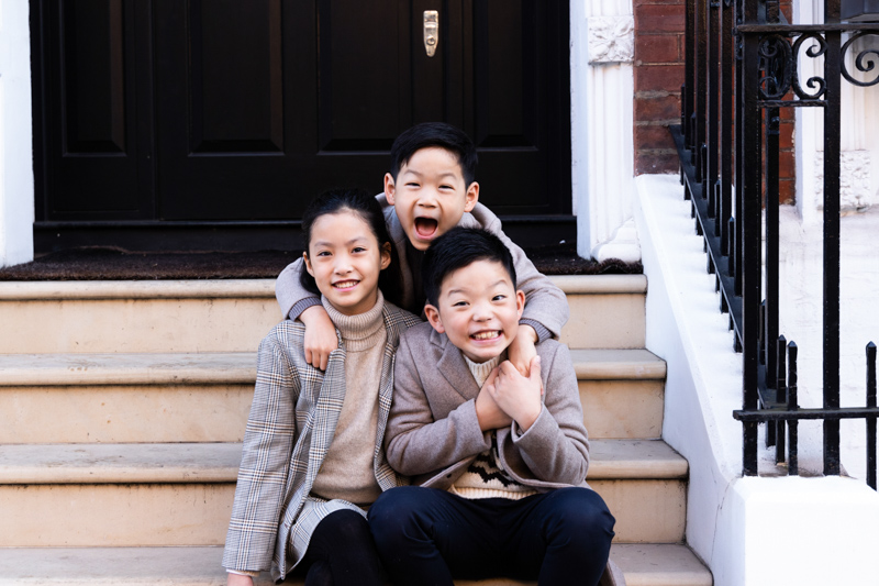 Three children sitting on a doorstep