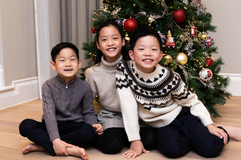 Three children in front of a christmas tree