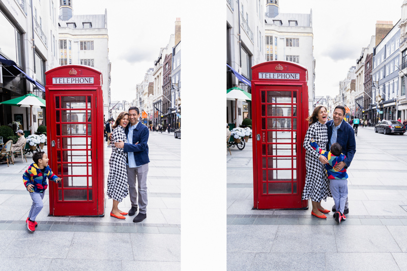 Man, lady and boy having fun next to a red London telephone box
