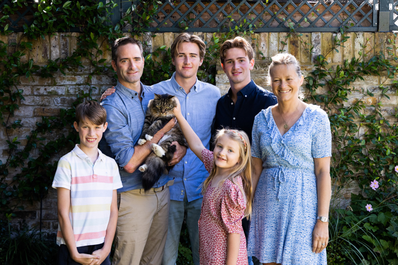 Mum, dad, 3 sons, a daughter and a cat smiling together
