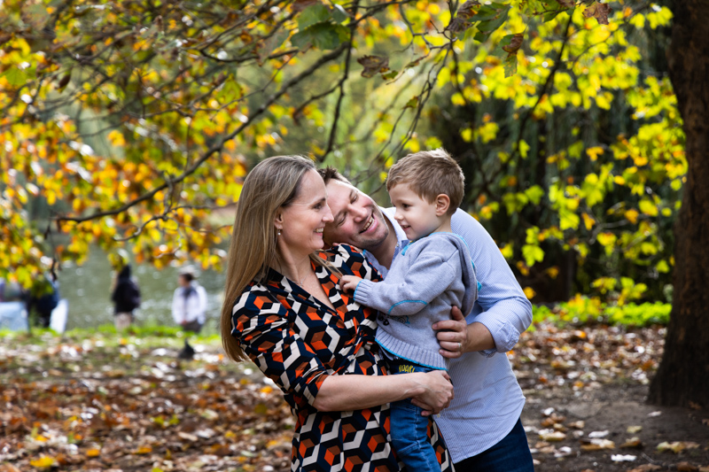 Family of three in front of Autumn leaves
