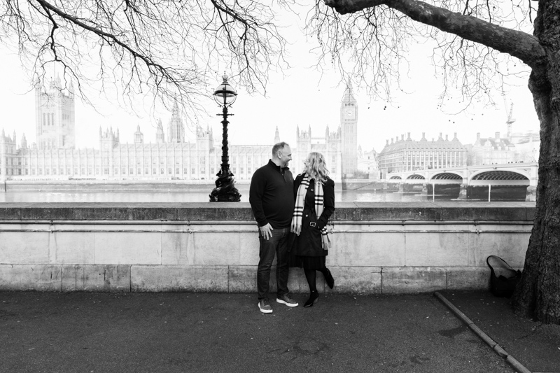 man and lady looking at each other with the Houses of Parliament behind them.