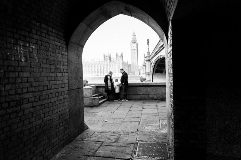 family through archway with houses of parliament in the background