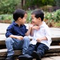 Twin boys smiling at each other.
